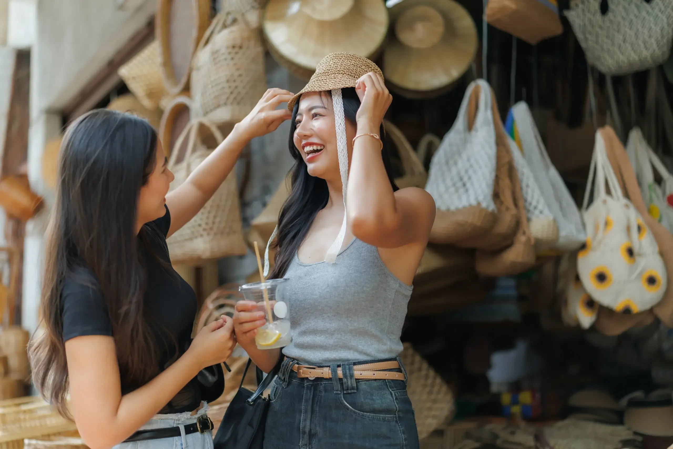 Two customers trying on handmade products at a local market, representing traditional retail experiences in the Philippine economy.