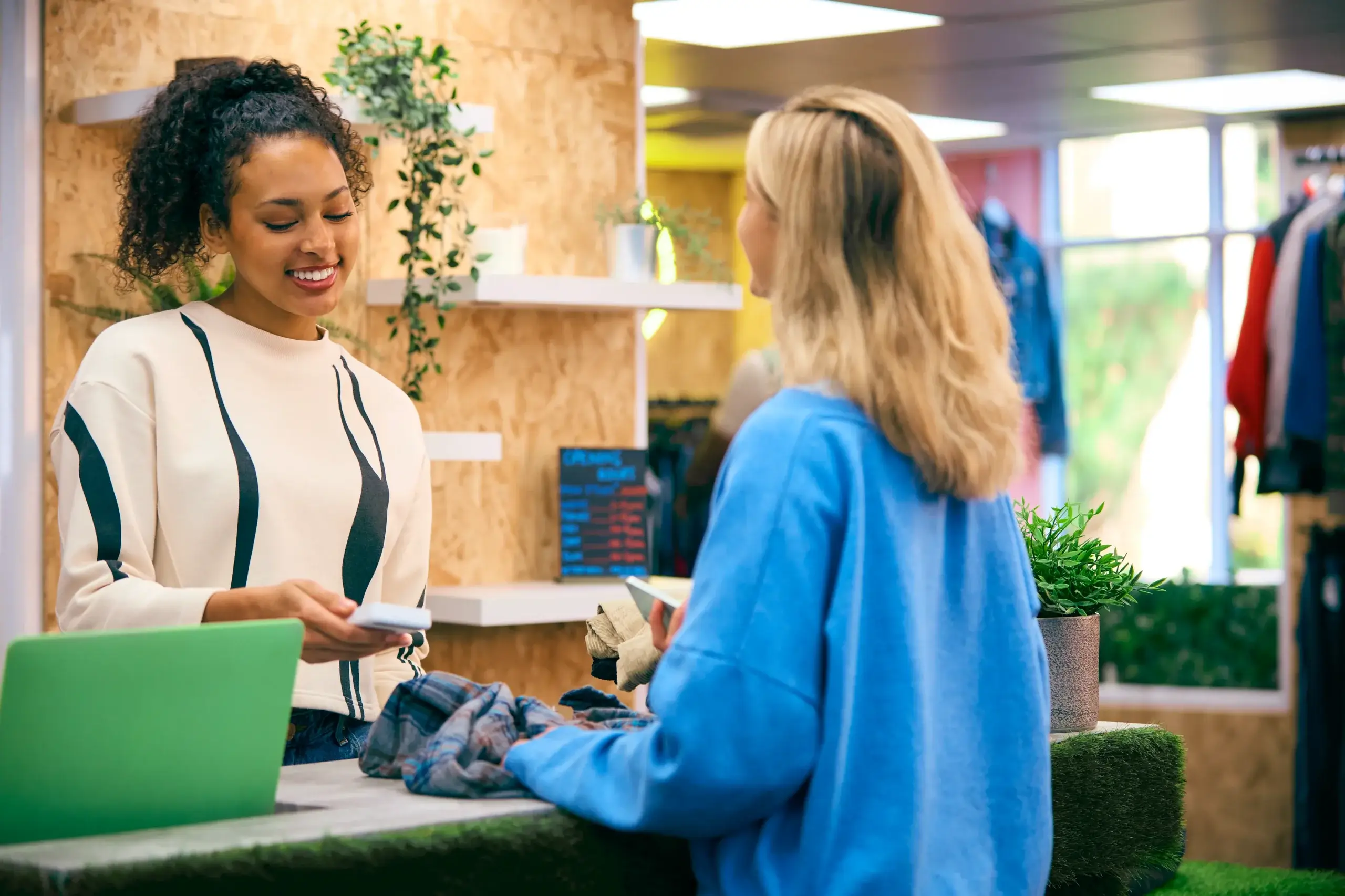 Customer making a payment using a gift shop POS system at a modern retail checkout counter