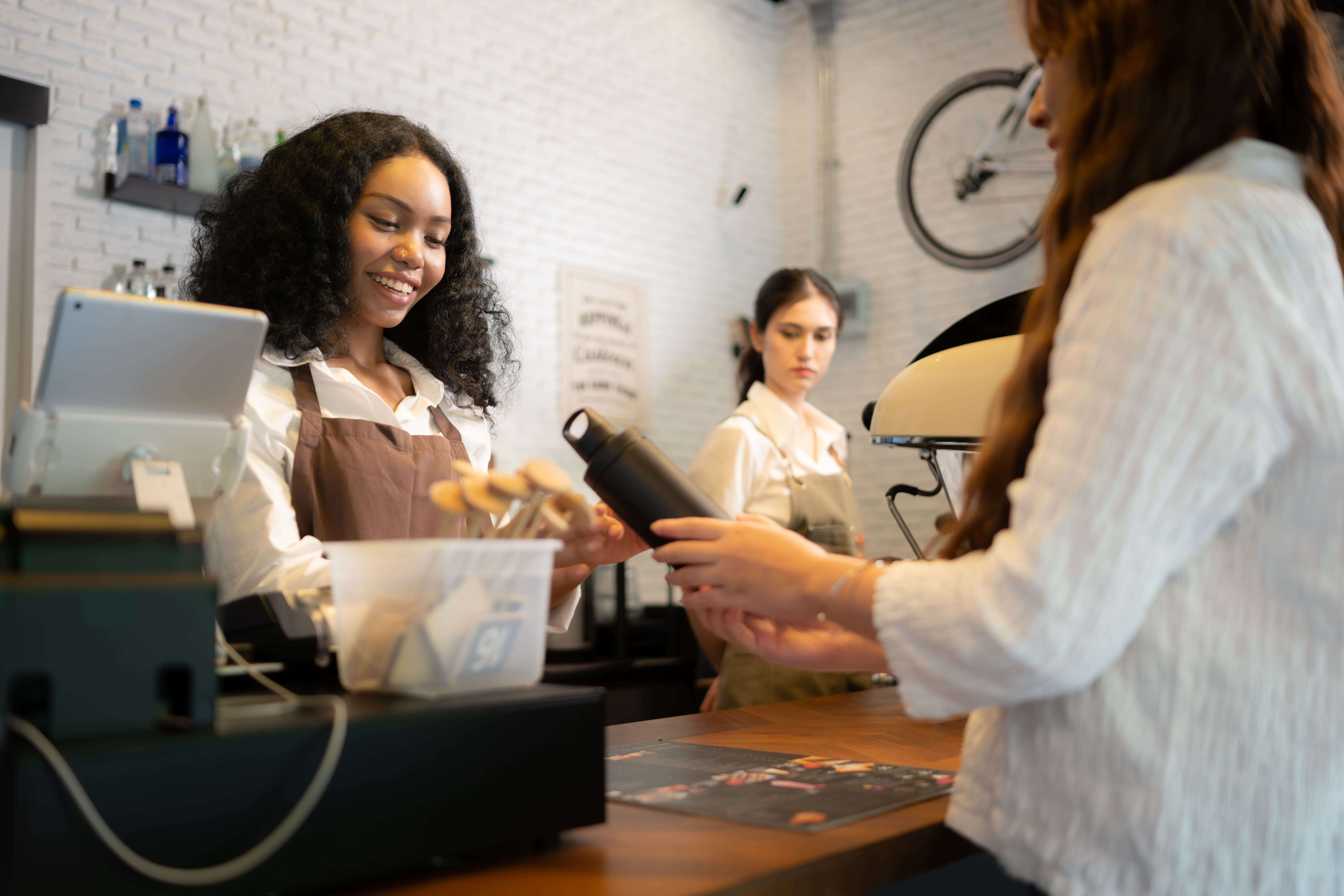 Female barista serving customers using a restaurant POS system