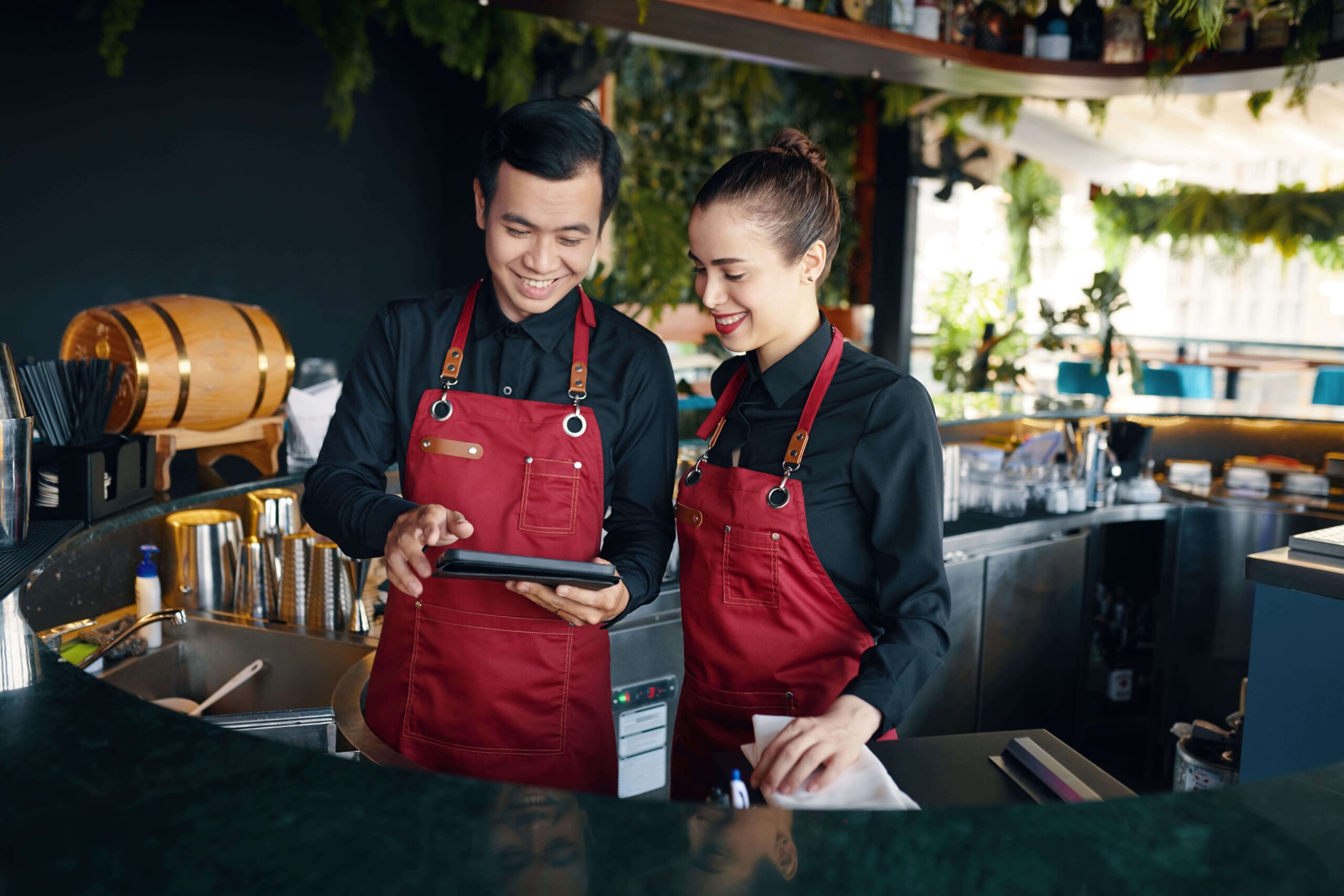 Bartenders checking drink orders on a digital tablet using a restaurant POS system