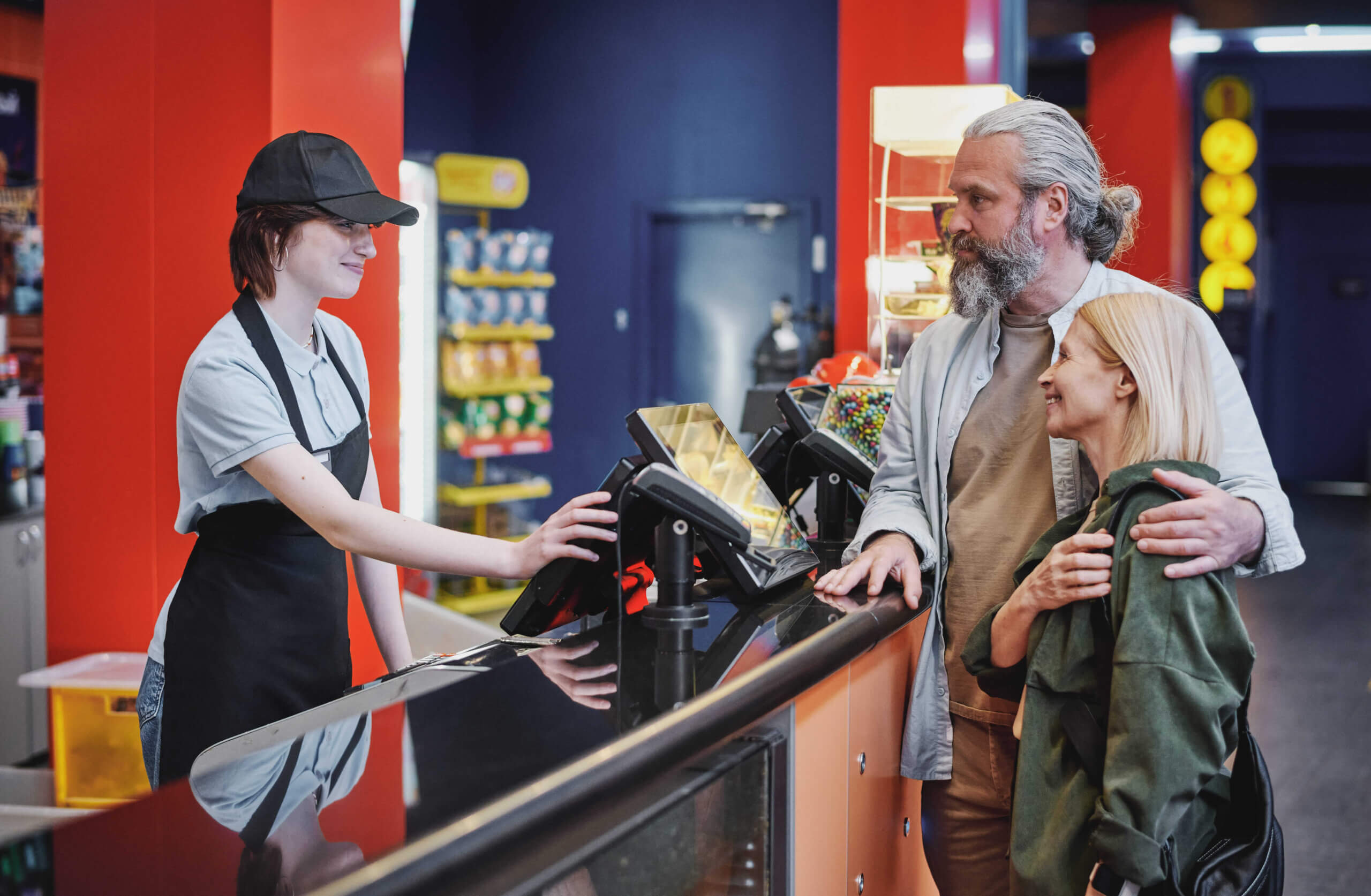 Customer buying popcorn at a cinema counter with digital POS system