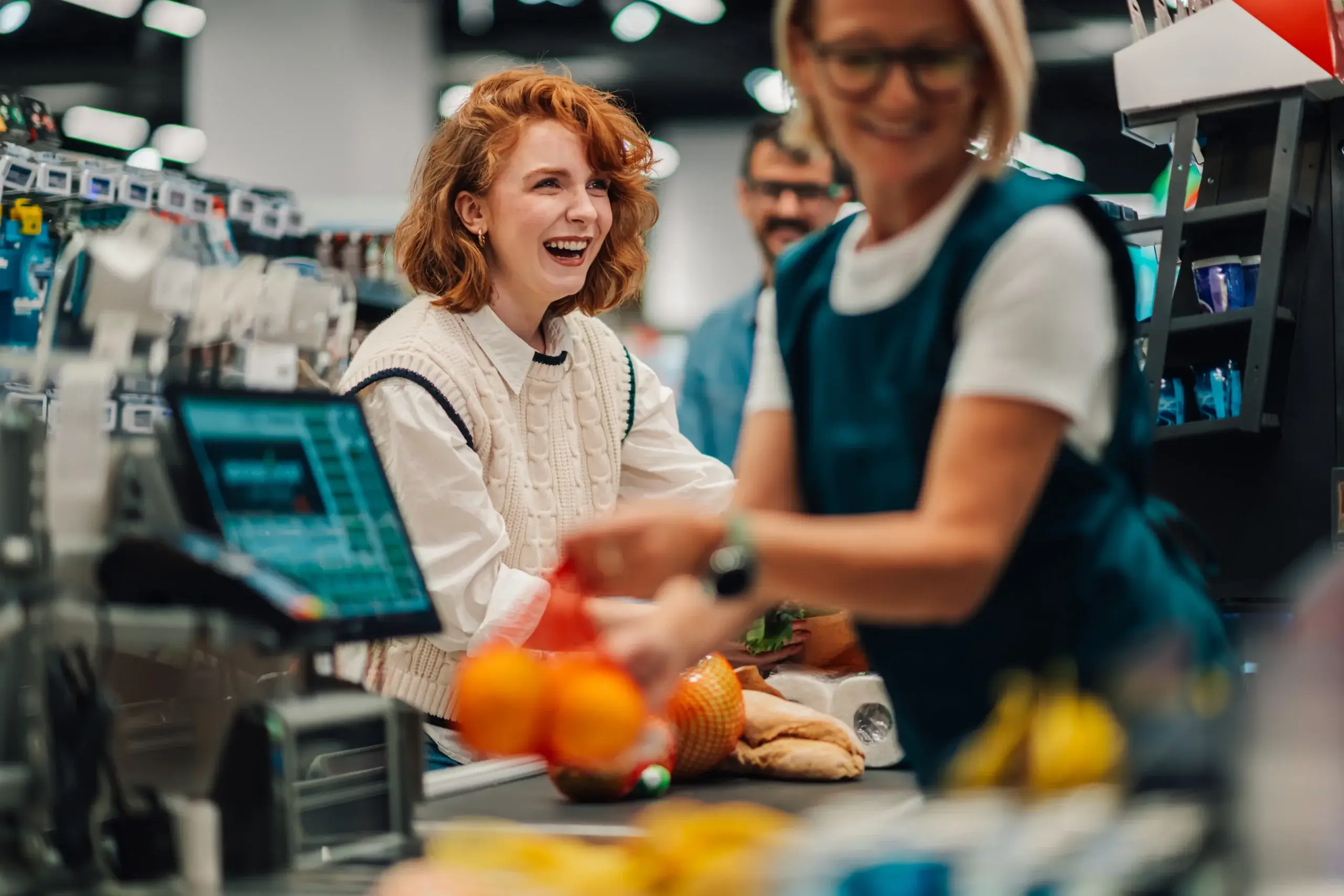 Cashier scanning grocery items using barcode scanner connected to POS system