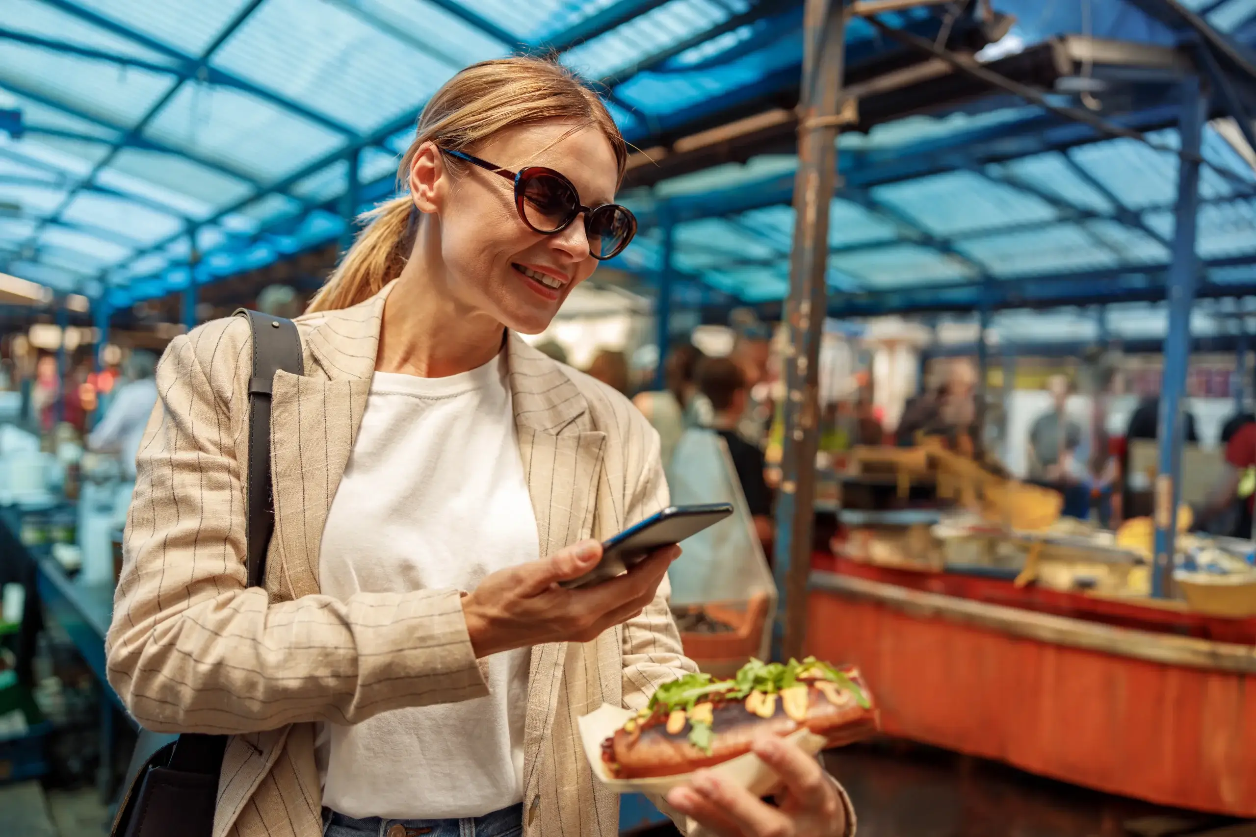 Customer taking photos of freshly prepared bakery food at market